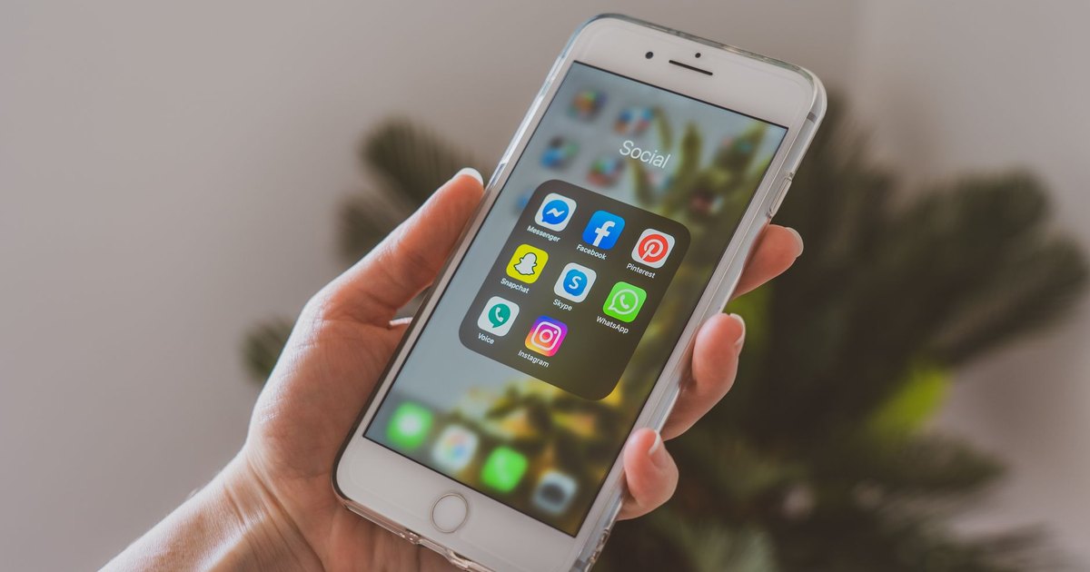 Ekranında sosyal medya uygulamaları açık akıllı telefon tutan el