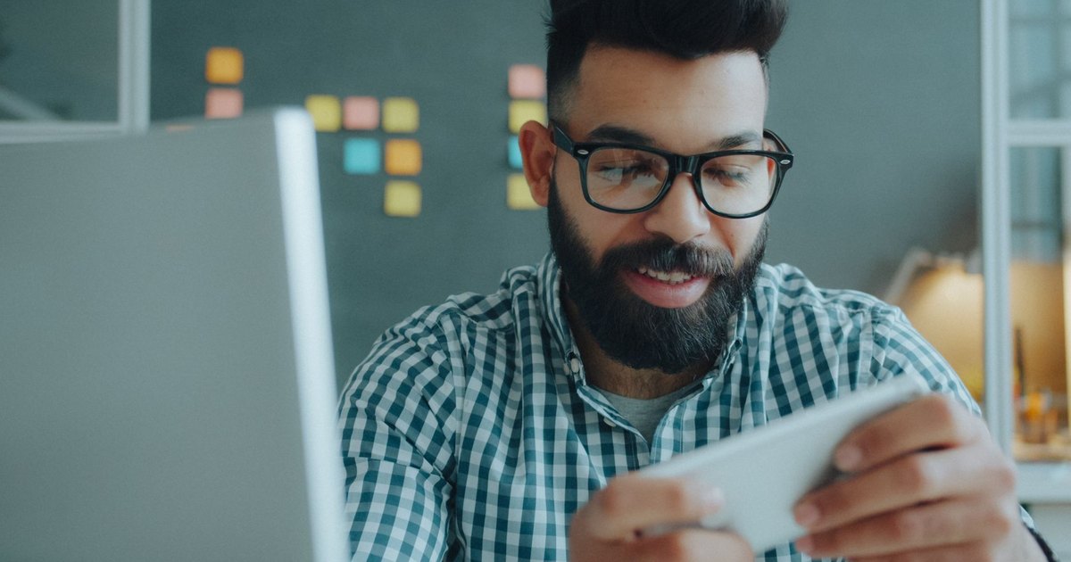 İş yerinde telefonunu kullanan gözlüklü adam