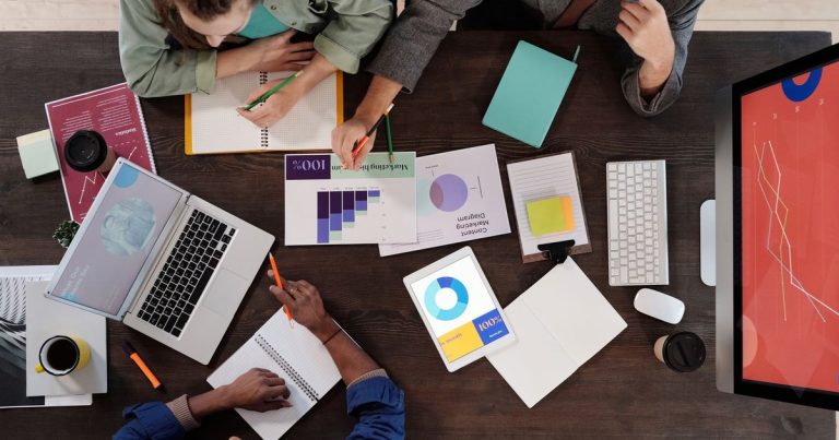 Modern ofiste bir proje üzerinde çalışan ekip, üstten görünüm