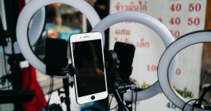 Halka ışıkların arasında tripoda takılı akıllı telefon