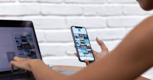 Dizüstü bilgisayar ve telefonla sosyal medya içeriği hazırlayan kadın