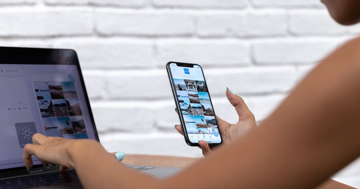 Dizüstü bilgisayar ve telefonla sosyal medya içeriği hazırlayan kadın