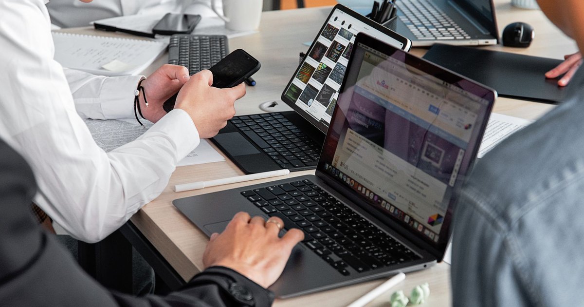 Modern ofiste dizüstü bilgisayar ve telefonlarla çalışan profesyoneller