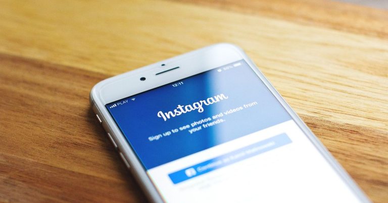 Ahşap masada Instagram giriş ekranı açık akıllı telefon