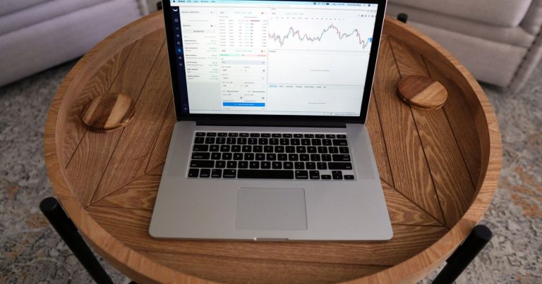 Şık ahşap masada grafik ekranı açık dizüstü bilgisayar