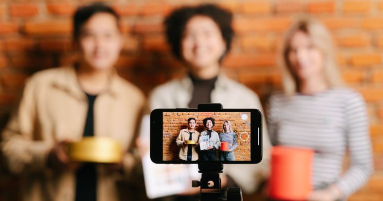 Tuğla duvar önünde telefonla video çeken ekip