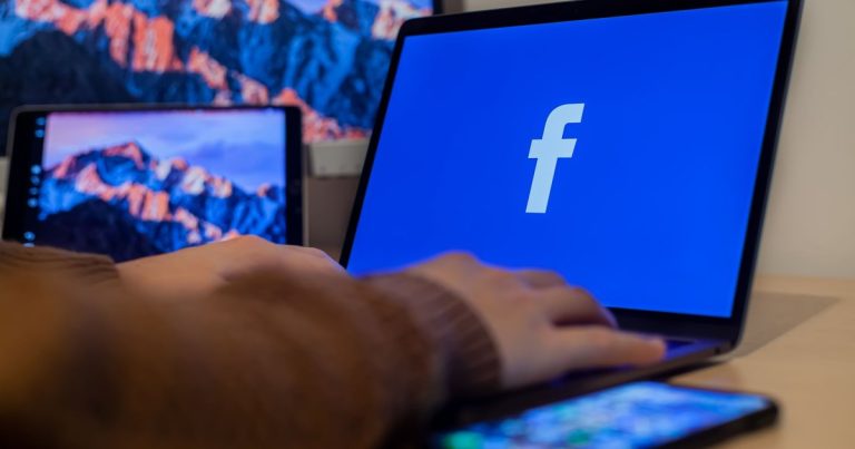 Birden fazla cihazın bulunduğu çalışma alanında Facebook açık dizüstü bilgisayar