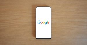 Ahşap masada Google ana sayfası açık akıllı telefon