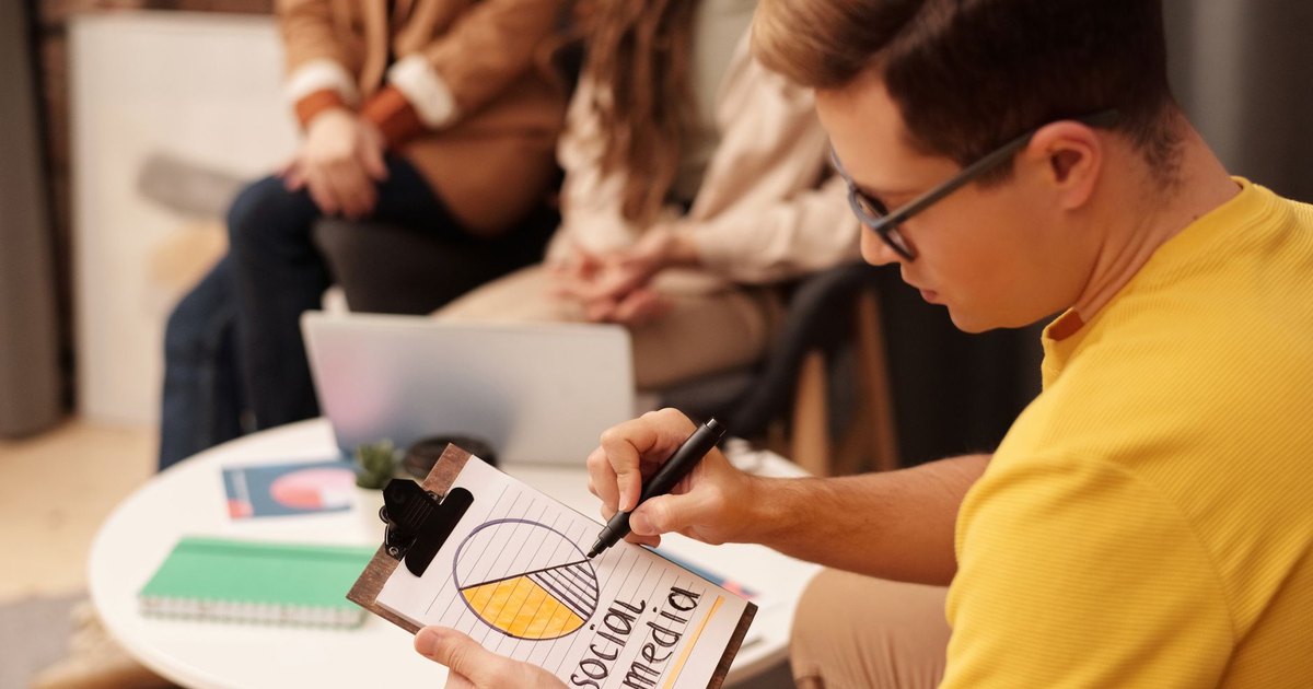 Modern ofiste sosyal medya stratejisini inceleyen genç profesyonel