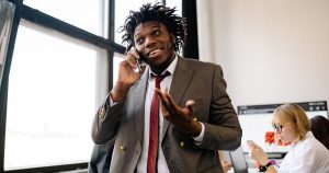 Ofiste telefonla konuşan güler yüzlü iş insanı