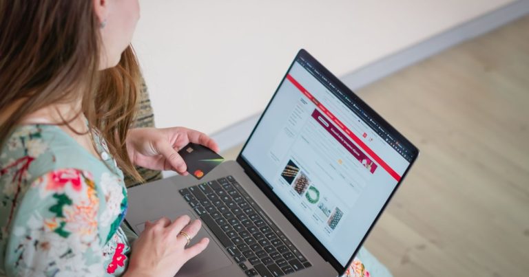 Dizüstü bilgisayar ve kredi kartıyla online alışveriş yapan kadın
