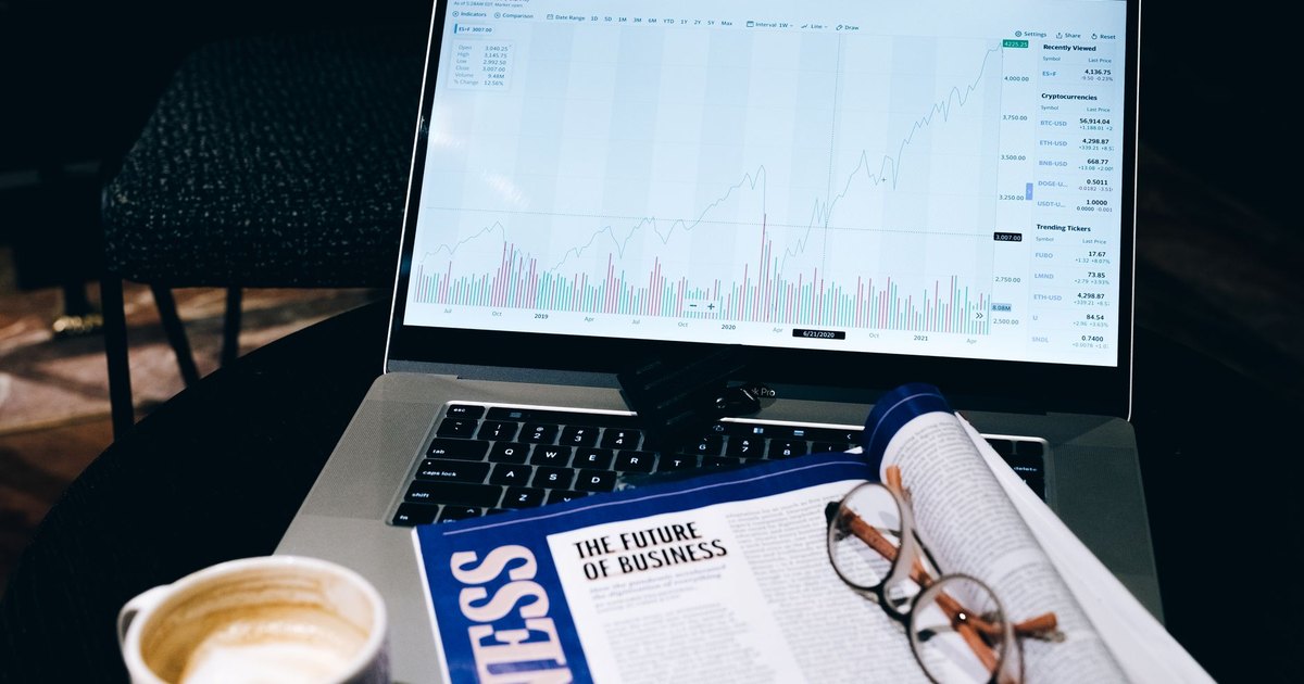 Ofis masasında dizüstü bilgisayar, iş dergisi ve kahve