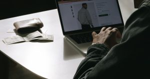 Cüzdanın yanında dizüstü bilgisayardan online alışveriş yapan kullanıcı