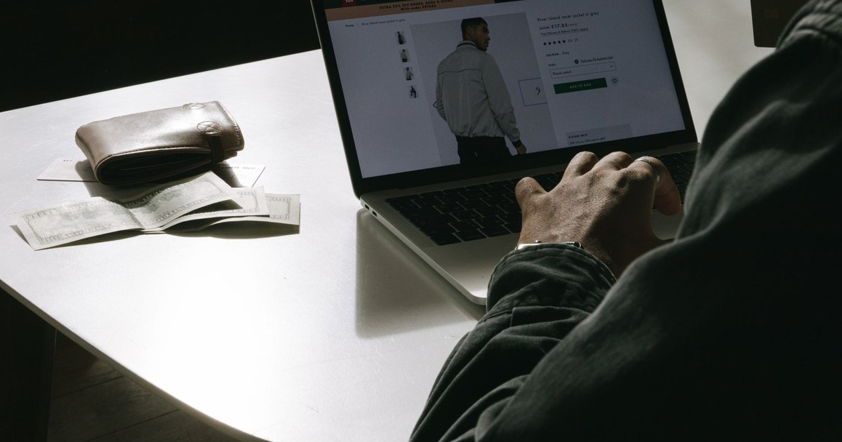 Cüzdanın yanında dizüstü bilgisayardan online alışveriş yapan kullanıcı