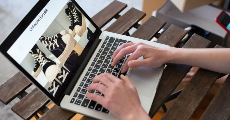 Dizüstü bilgisayarda online mağazanın ayakkabı ürün sayfasını inceleyen kullanıcı