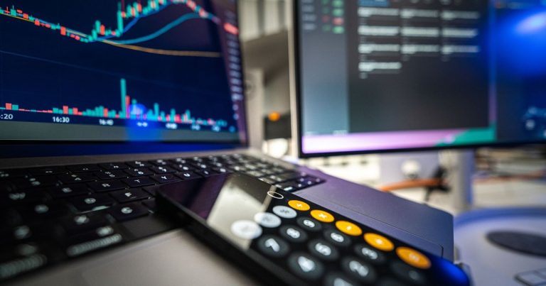 Dizüstü bilgisayar, ekran ve hesap makinesiyle finansal analiz