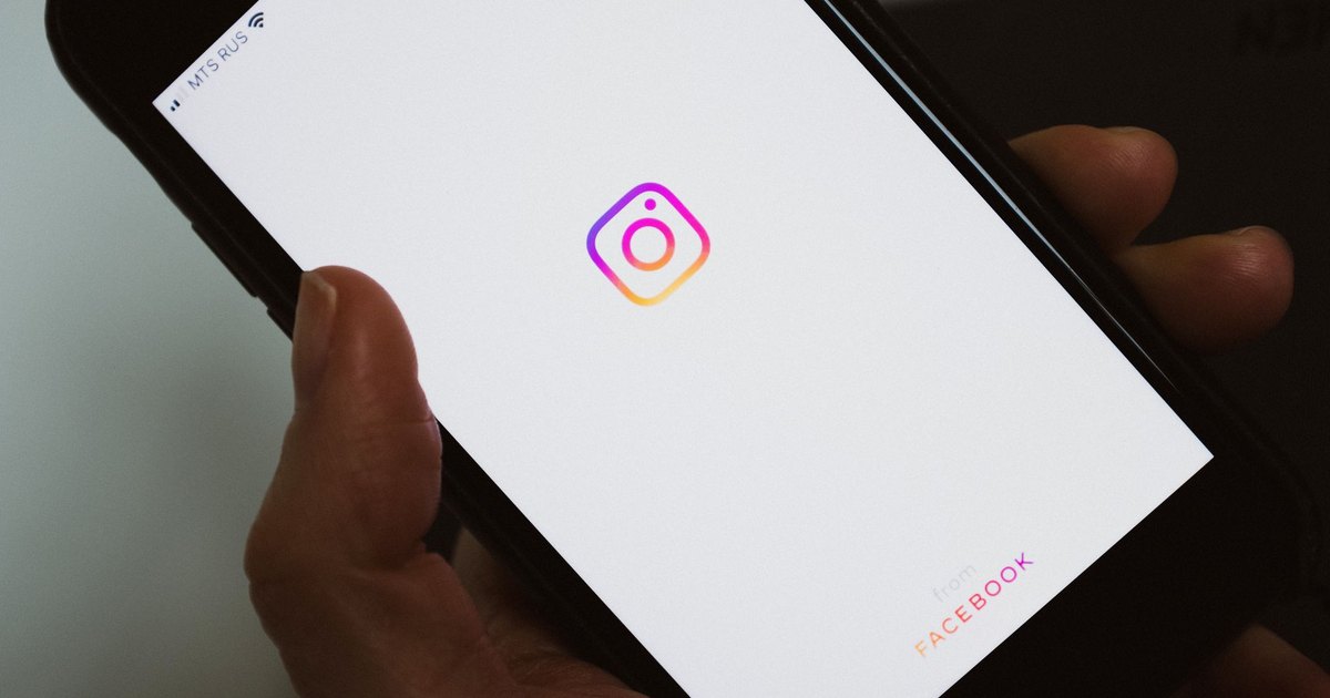 Ekranında sosyal medya uygulaması simgesi olan telefonu gösteren kişi