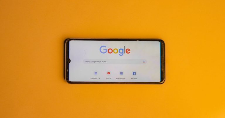 Sarı zemin üzerinde Google arama sayfası açık akıllı telefon