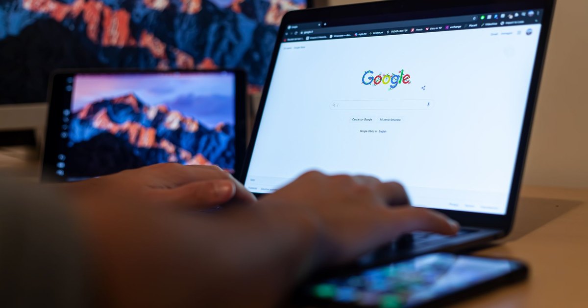 Ekranında Google açık dizüstü bilgisayarda yazı yazan eller