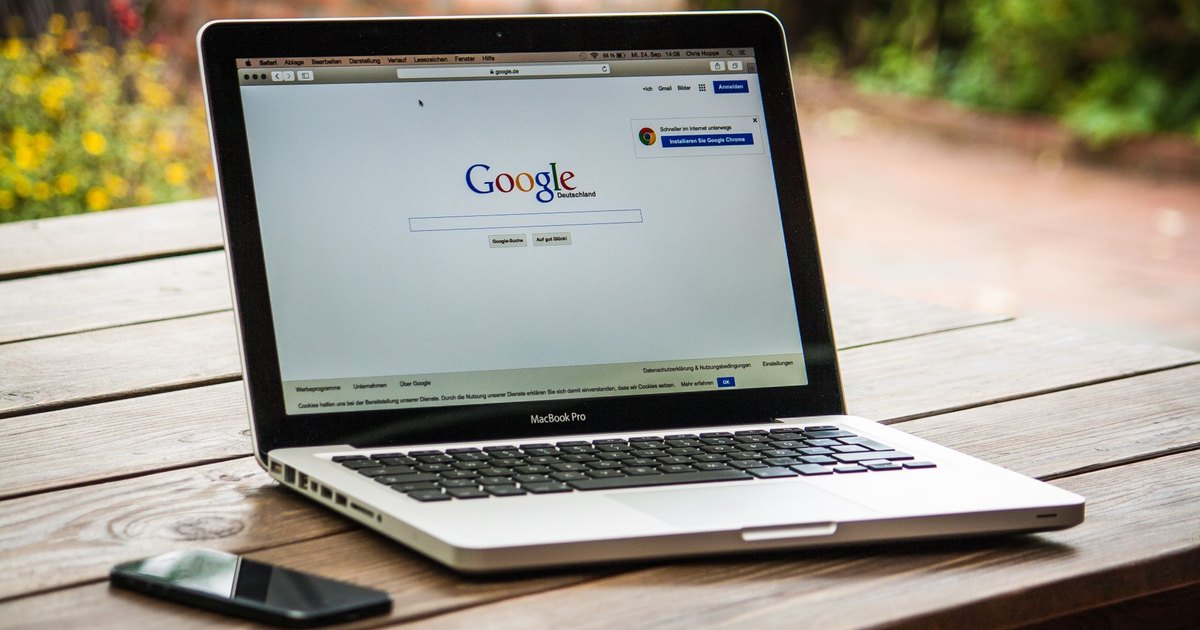Dış mekânda ahşap masada Google arama sayfası açık dizüstü bilgisayar