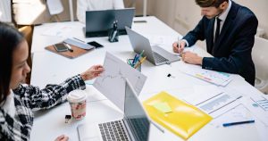 Modern ofiste dizüstü bilgisayarlar ve belgelerle çalışan profesyoneller