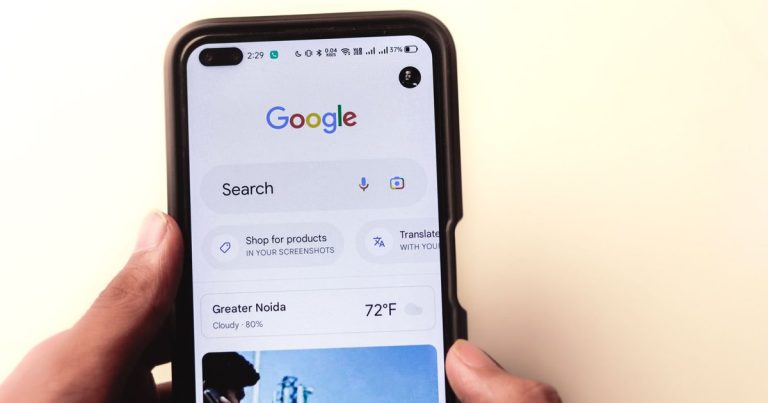 Ekranında Google araması açık akıllı telefon tutan el