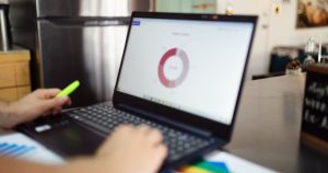 Modern bir ortamda dizüstü bilgisayarda iş verisi inceleyen kişi