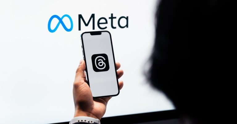 Meta logosu önünde Threads logosu açık akıllı telefon tutan eller