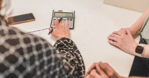 Masada hesap makinesi ve belgelerle hesap yapan eller