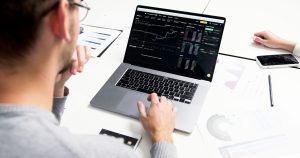 Dizüstü bilgisayarda piyasa verilerini inceleyen iş insanı