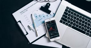 Finansal belgeler, dizüstü bilgisayar ve veri gösteren telefon, üstten görünüm