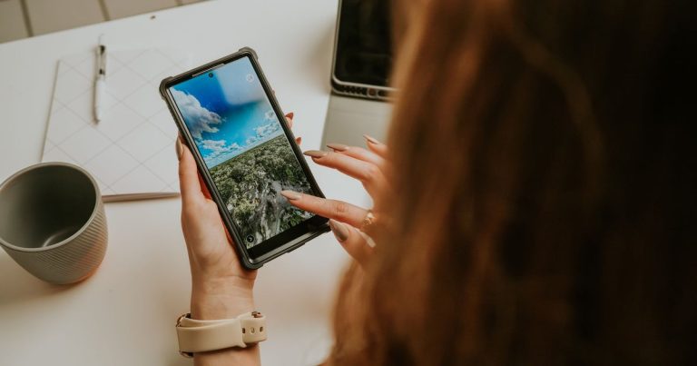 Ofiste masada akıllı telefon kullanan kadın