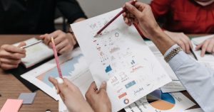 Toplantıda iş raporlarını ve grafikleri inceleyen ekip