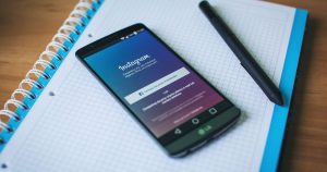 Not defteri üzerinde Instagram açık akıllı telefon ve kalem